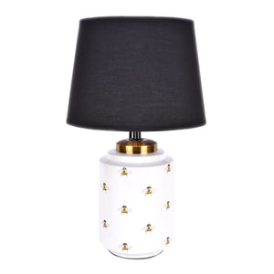 white ceramic table lamp features an all over pattern of bumble bees with black cotton shade