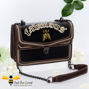 Rock chic styled vegan leather handbag featuring bold golden "Fabulous" embroidery with vintage gold bee embellishment in black colour.
