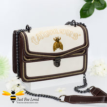 Load image into Gallery viewer, Rock chic styled vegan leather handbag featuring bold golden "Fabulous" embroidery with vintage gold bee embellishment in cream colour.