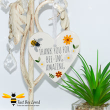 Load image into Gallery viewer, a ceramic hanging heart plaque decorated with bees and daisies and "thank you for bee-ing amazing" text.