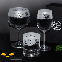 Load image into Gallery viewer, A set of three etched glass drinkware items with a frosted bee and flower design, including a whiskey tumbler, a balloon gin glass, and a stemmed wine glass.