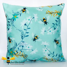 Load image into Gallery viewer, Scatter cushion with embroidered bumblebees in a field of flowers in teal colour.