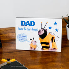 Load image into Gallery viewer, Wooden desk plaque with the text 'DAD You're the bee's knees!' and an illustration of a small bulldog wearing a bee costume looking up at a larger bulldog, which represents the dad.