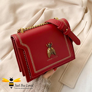 Vegan leather handbag with large gold bee embellishment in red