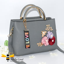 Load image into Gallery viewer, hand-crafted 3D embellished PU leather shoulder handbag featuring a cluster bouquet of colourful flowers, golden leaves with a pearlised bee in grey colour