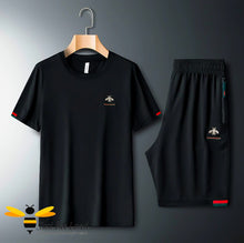 Load image into Gallery viewer, 2-piece black t-shirt and shorts embroidered with a gold bee and colour coordinating red & green stripes.