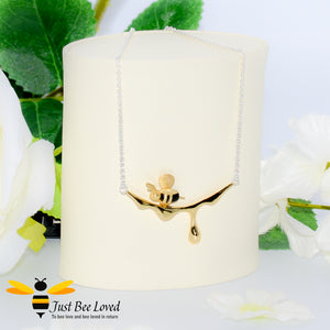 handcrafted sterling silver necklace featuring a design of an 18kt gold plated and black 3D honey bee resting upon golden dripping honey. 