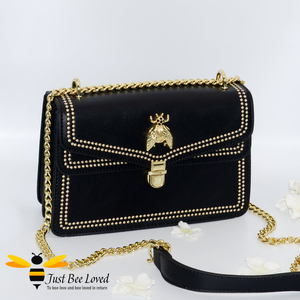 Black vegan leather evening handbag with embroidery edged stitching and large gold bee embellishment