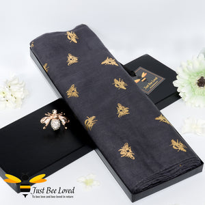 ladies scarf featuring metallic gold bumble bee print in charcoal colour, gift boxed with crystal bee brooch. 