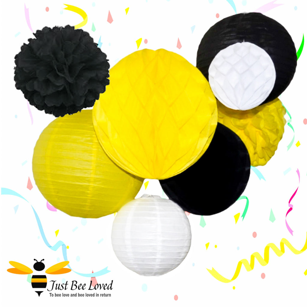 Bee theme hanging paper pom poms, lanterns, balls in yellow, black, white.