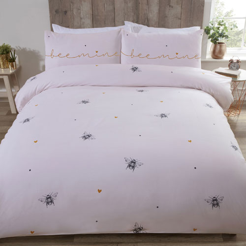 Soft pink coloured duvet cover set featuring bumble bees and hearts with 'bee mine' calligraphy on pillows.