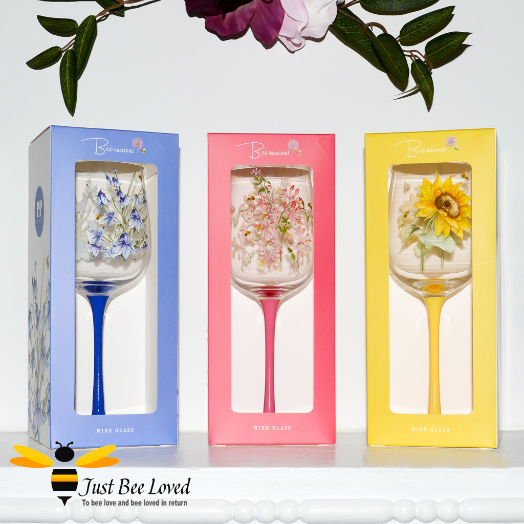 Tall stemmed wine glasses with florals and bumble bees decoration in gift boxes.