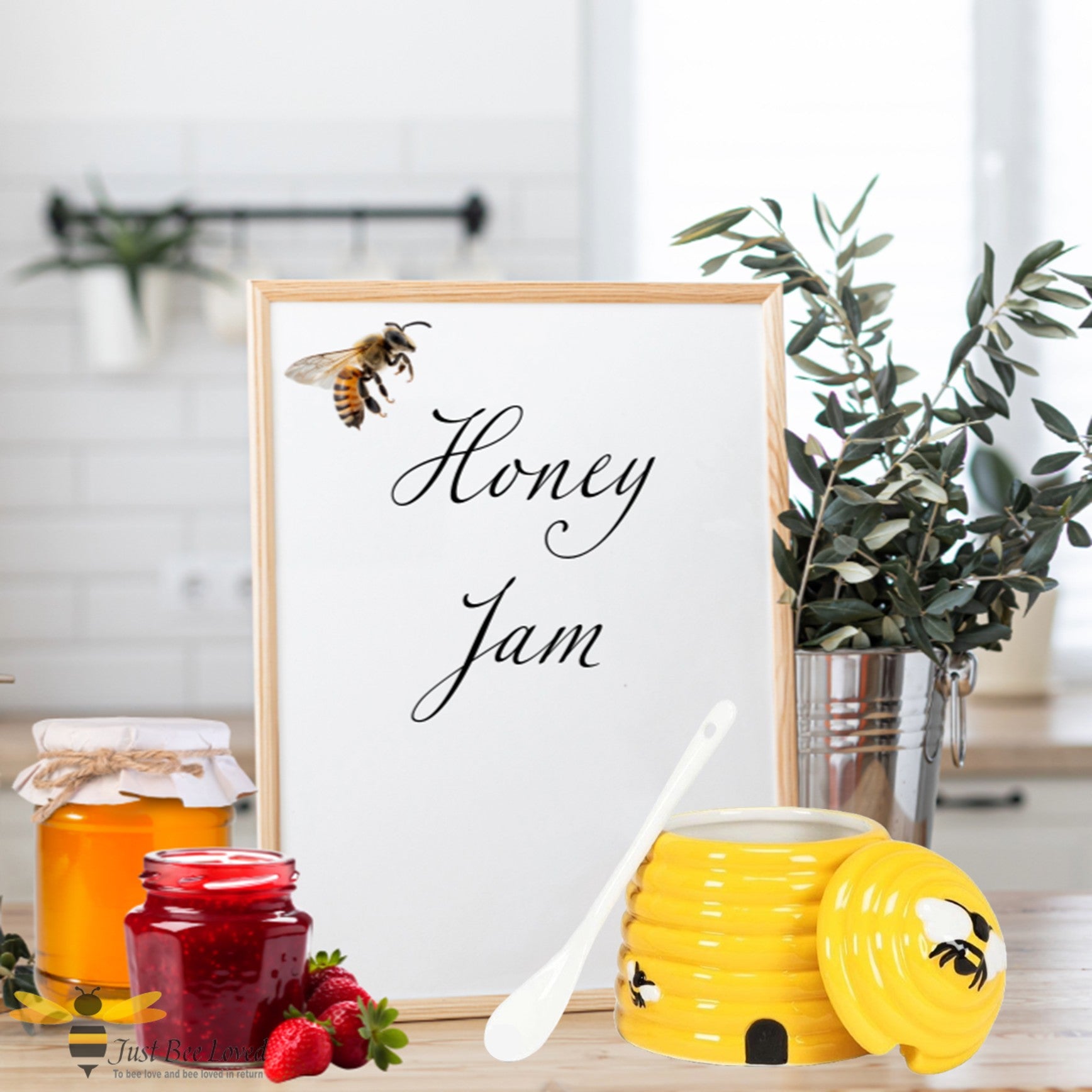 Framed print with a bee and 'Honey Jam' text, surrounded by honey jars, a jar of jam and a yellow hive shaped pot with bee design.