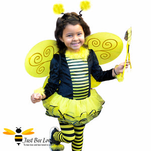 Mixed race girl wearing bumble bee fancy tutu dress costume with tights, wings, wand, head piece.