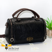 Load image into Gallery viewer, Boston styled faux leather barrel shaped black handbag featuring a vintage bronze bee embellishment.
