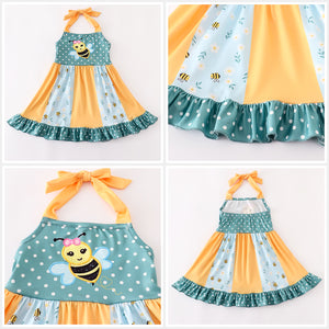 Girl's halter neck smock dress in orange and green with bumble bees print