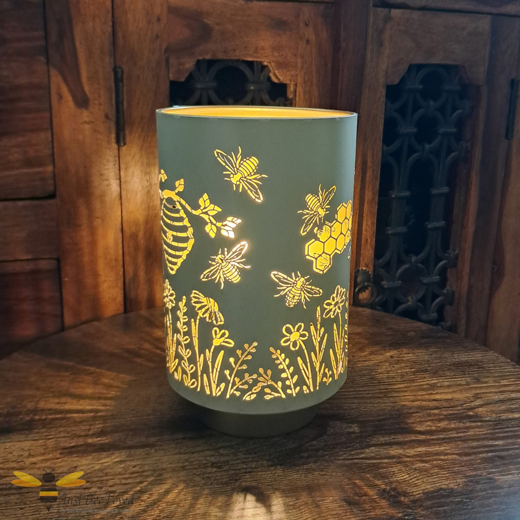Decorative table lamp with bee and honeycomb silhouette design.
