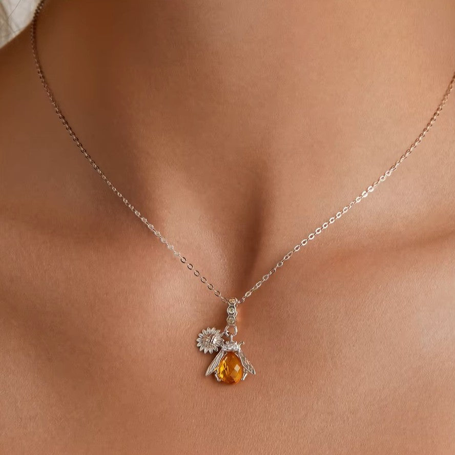 Sterling silver bee pendant necklace with a small silver sunflower charm.