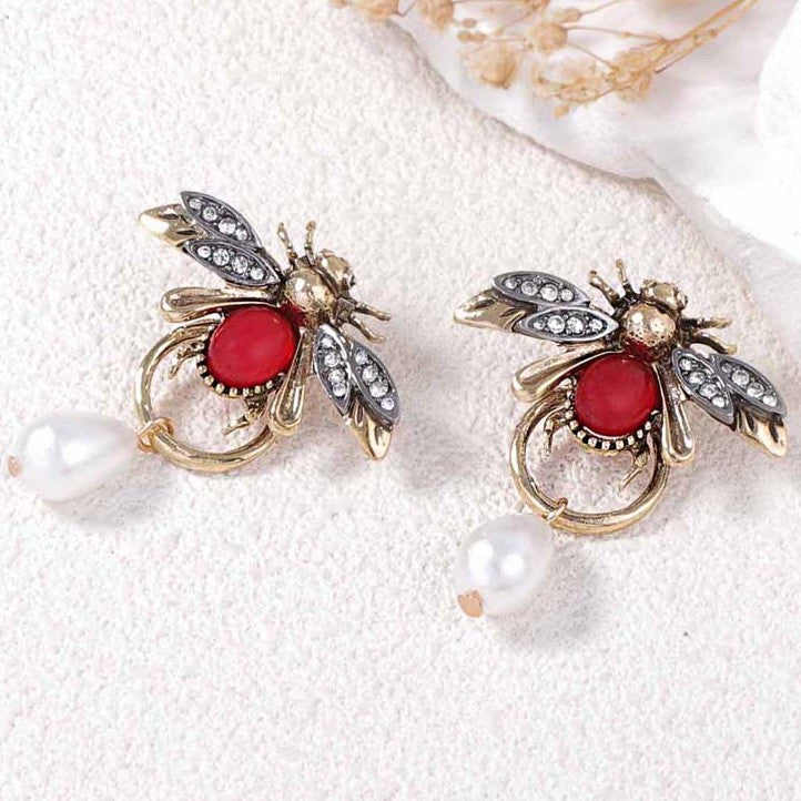 Vintage style bee shaped earrings with a teardop imitation pearl in gold colour.