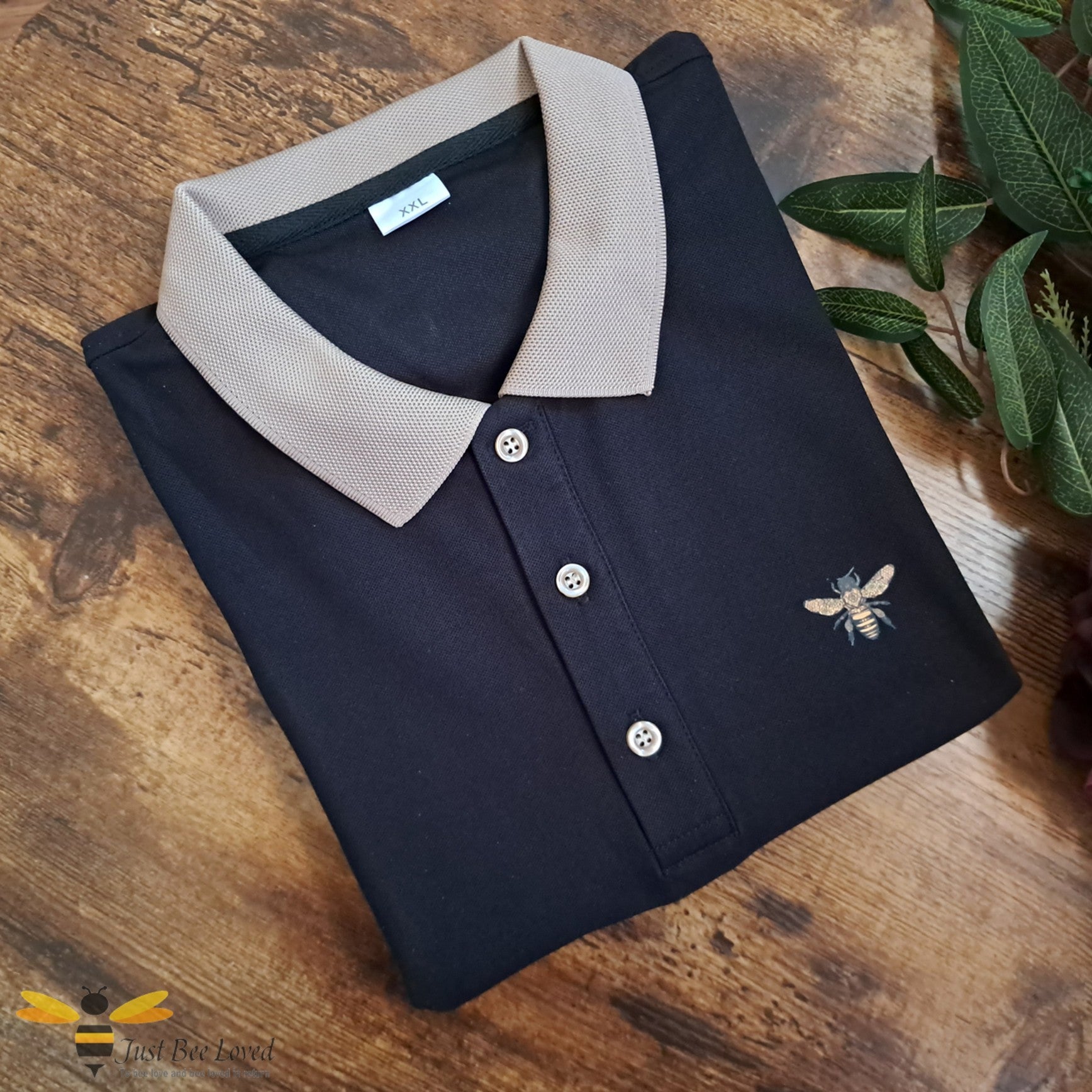 Black polo shirt with bee motif detailing and beige collar.