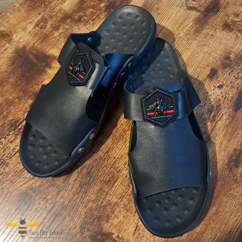 Men's black faux leather slides, indoor slippers with an embroidered bee motif applique.