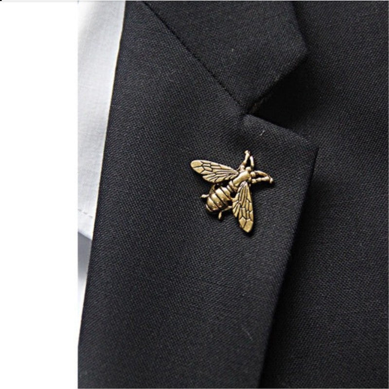 Gold bee-shaped lapel pin on a black suit jacket