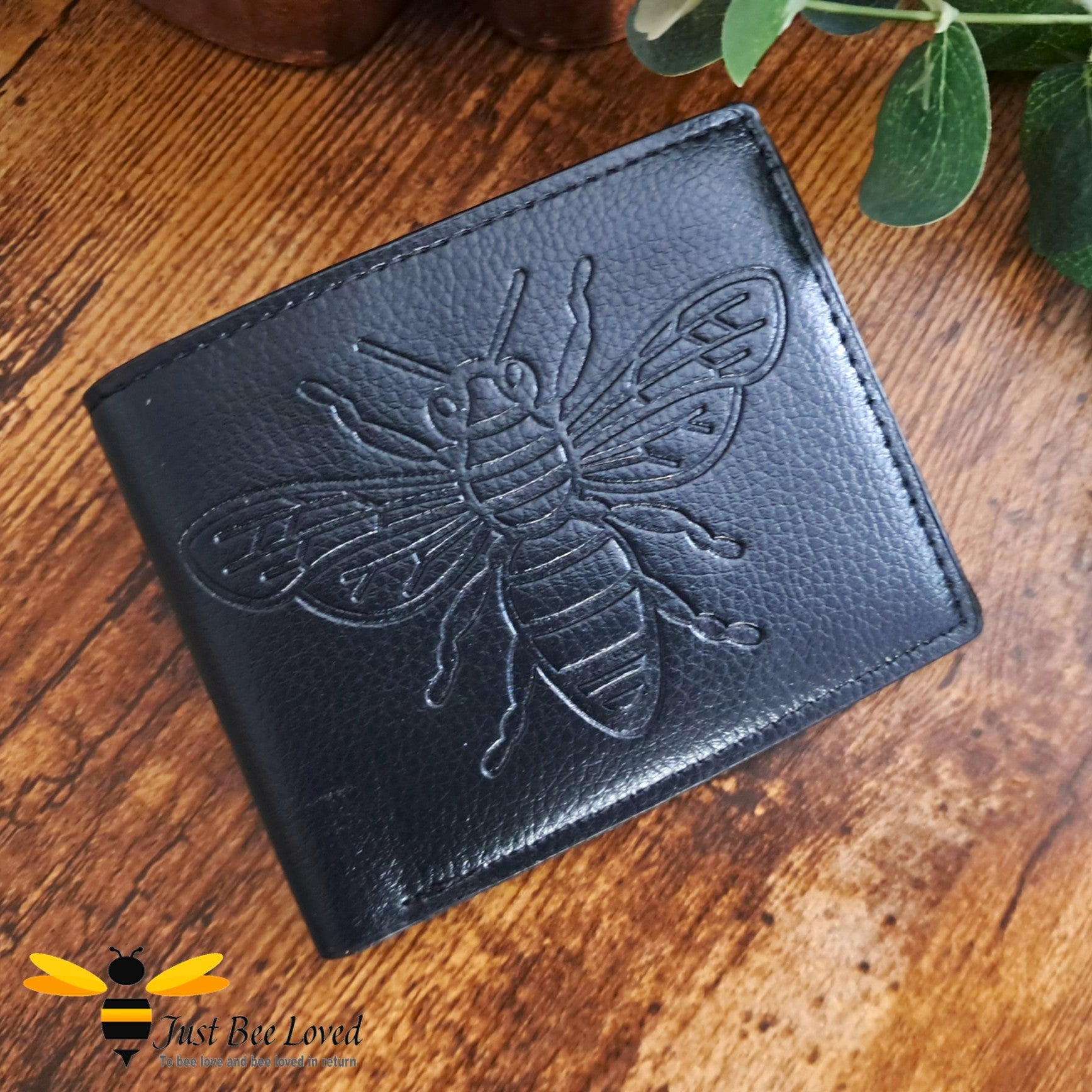 Black leather wallet with large embossed bee design.