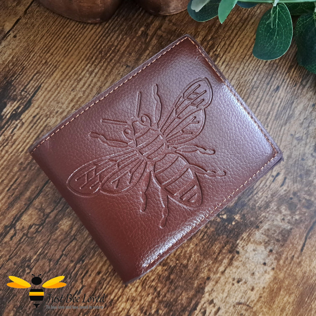 Brown leather wallet with large embossed bee design.