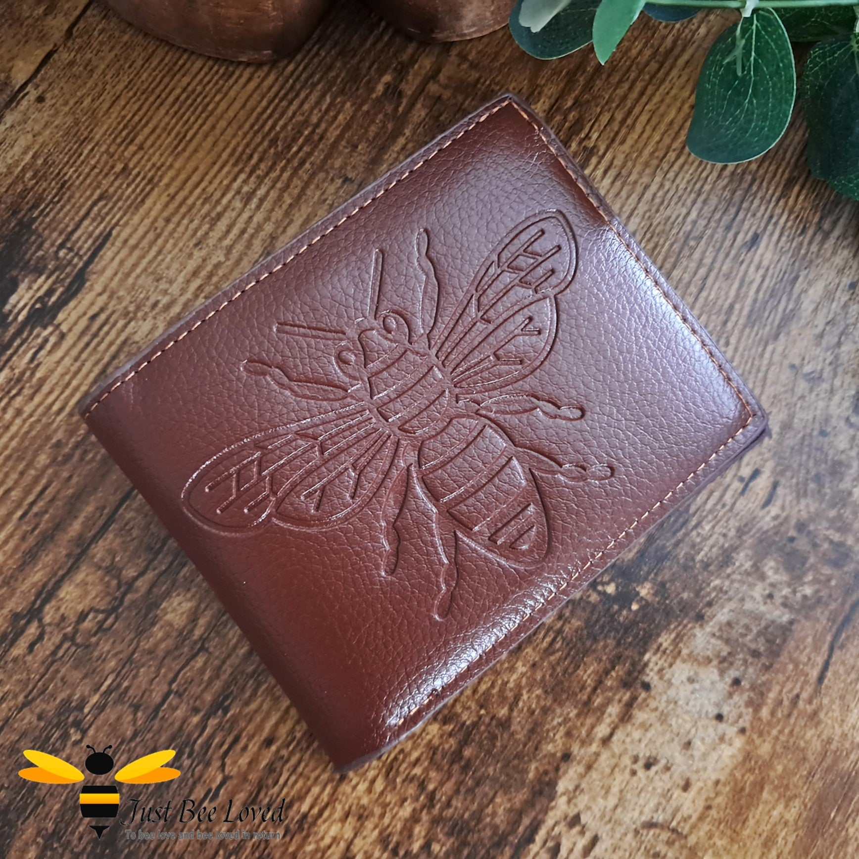 Brown leather wallet with large embossed bee design.