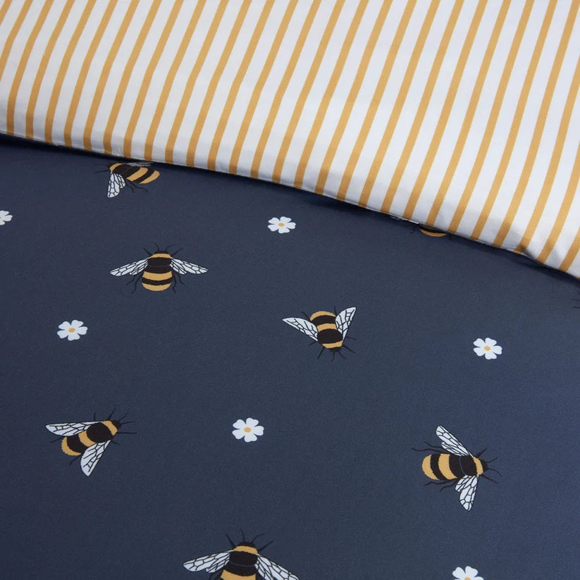 Navy blue duvet cover with an all over print of bees and daisy flowers