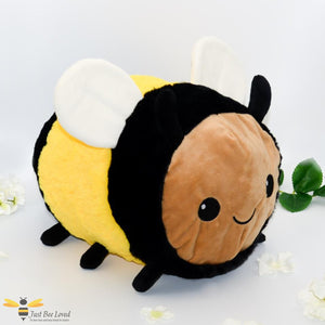 A medium sized plush soft toy bee with a smiling face.