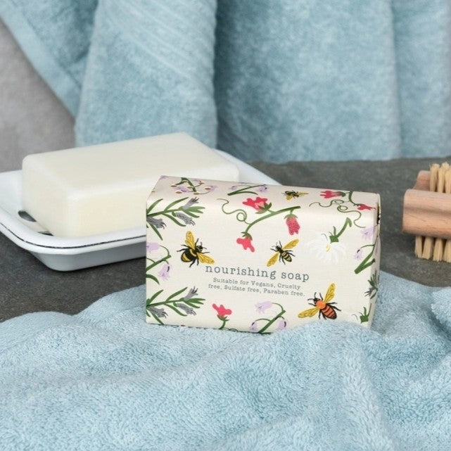 Bars of vegan hand soap with floral and bee themed design packaging.