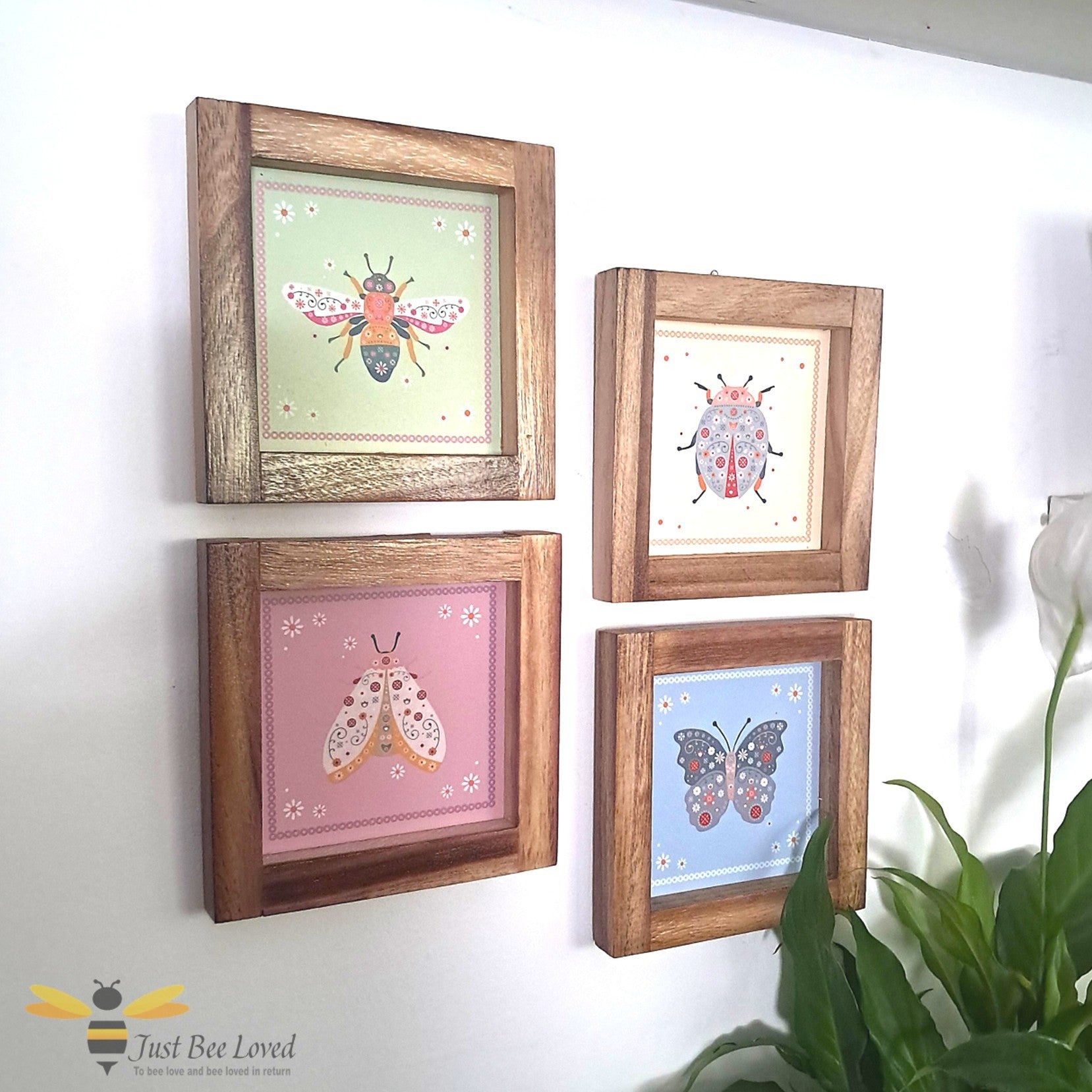 Set of four wooden-framed floral illustrations of a bee, butterfly, ladybird, and a moth.