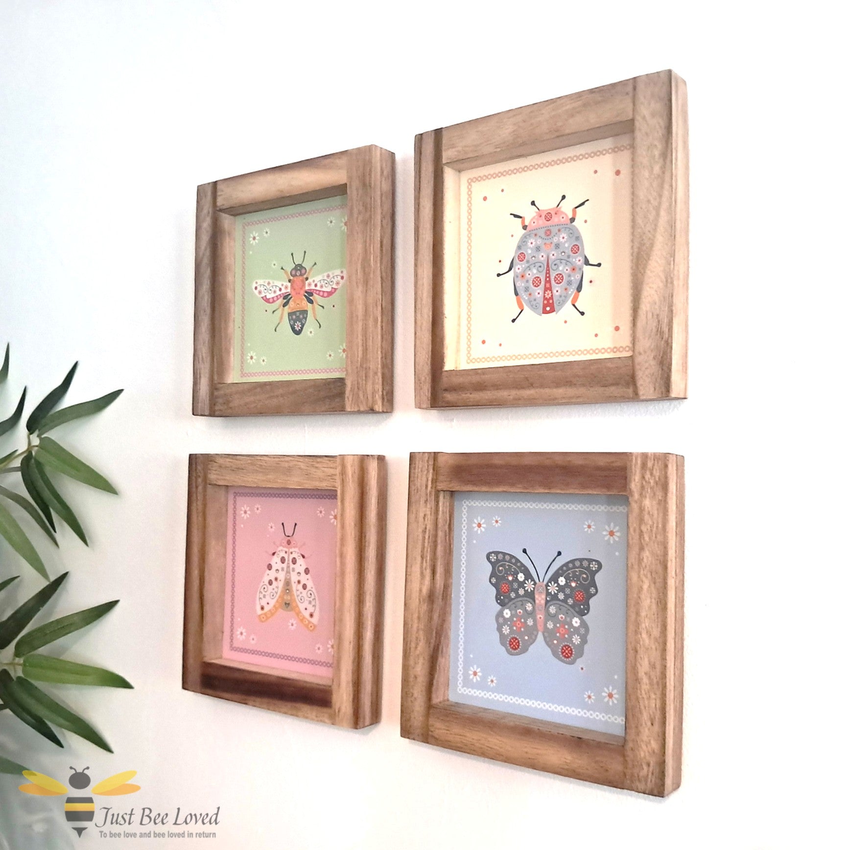 Set of four wooden-framed floral illustrations of a bee, butterfly, ladybird, and a moth.