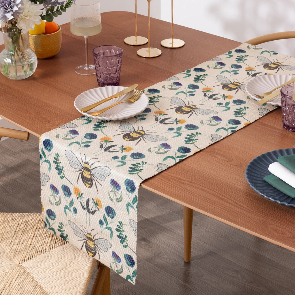Wylder Nature woven fabric dining table runner featuring a repeating bee patterned and florals design. 