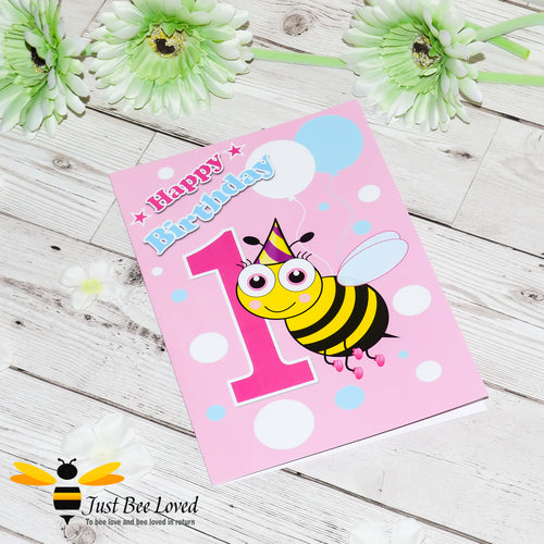 Happy 1st Birthday bee greeting card for girl featuring a cartoon bee with a party hat and balloons on a pink and white background.