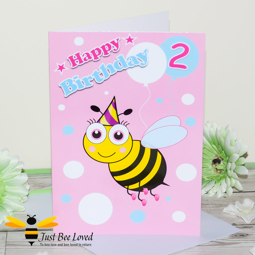 a birthday greeting card for girl featuring a cartoon bee wearing a party hat, holding balloons with the number 2 and 'Happy Birthday' text.