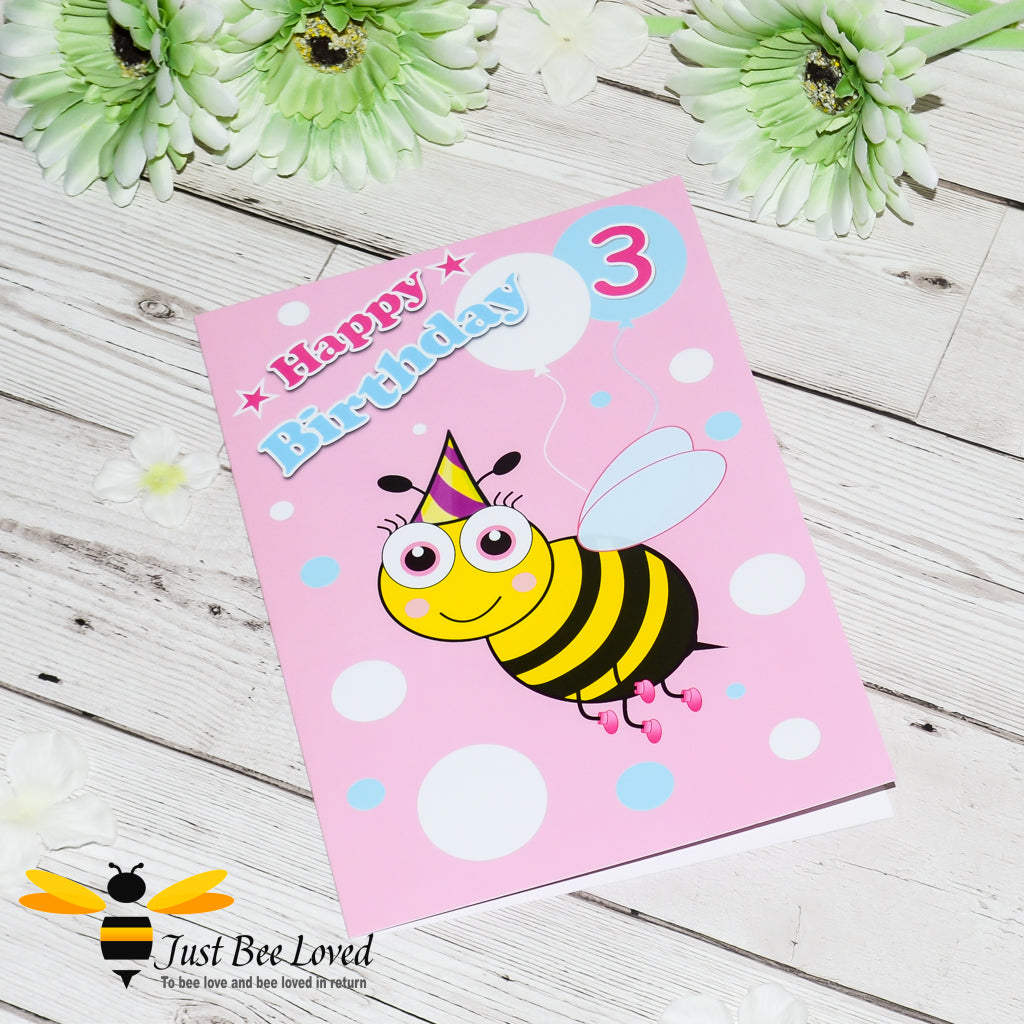 Pink greeting card with a cartoon bee design and text 'Happy Birthday' with colourful balloons and the number 3.