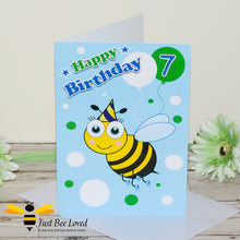 Load image into Gallery viewer, a 7th birthday greeting card for boy featuring a cartoon bee wearing a party hat with colourful balloons and the number 7.