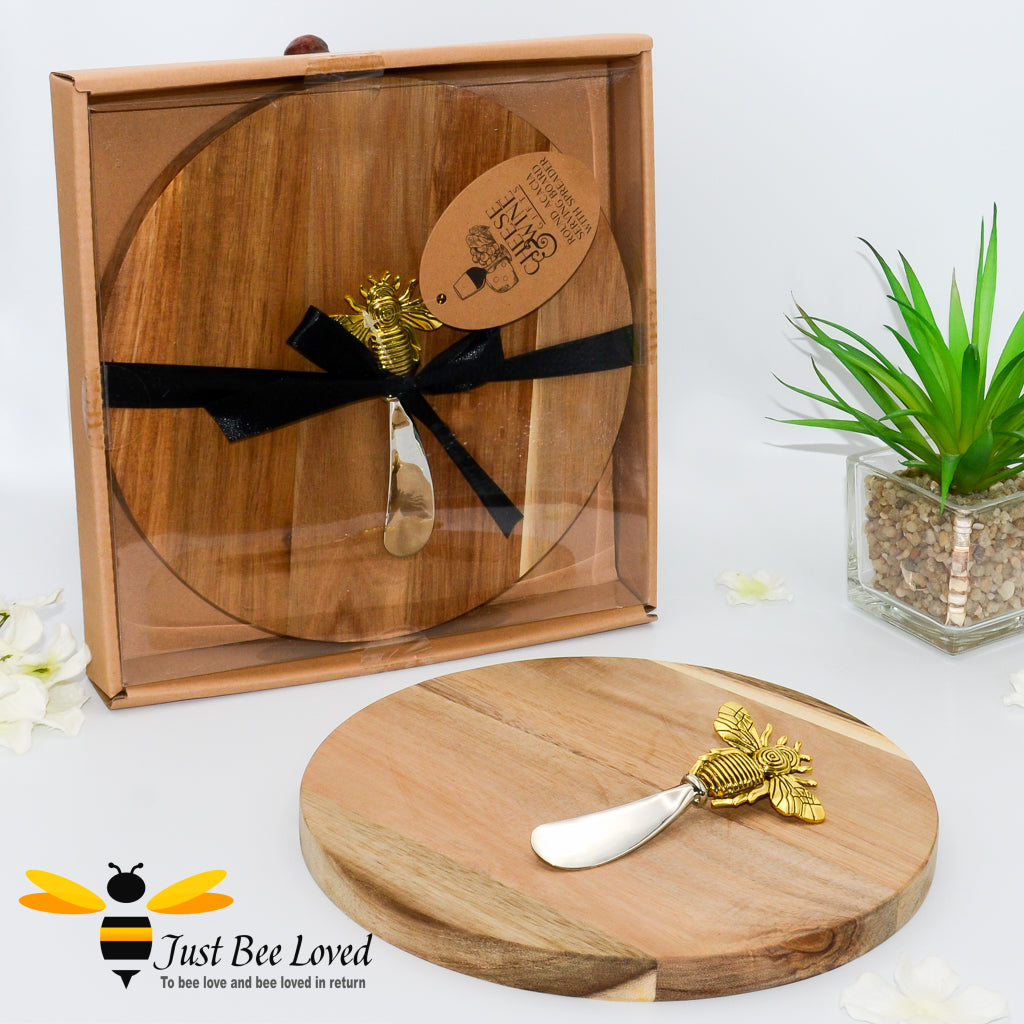 Acacia wood round cheese board with stainless steel spreader featuring a brass bee handle gift set