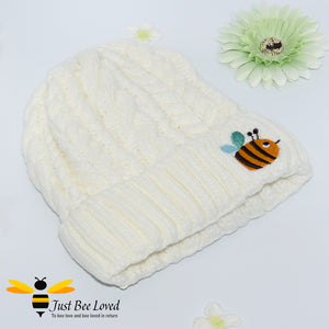 Aran style knitted hat featuring an embroidery bumblebee on front in cream colour