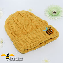 Load image into Gallery viewer, Aran style knitted hat featuring an embroidery bumblebee on front in mustard colour