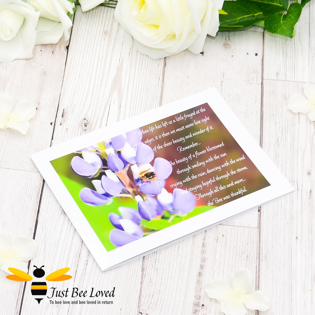 a greeting card showing a landscape photographic print of a wild bee foraging on purple lupine flowers with an accompanying inspirational verse.
