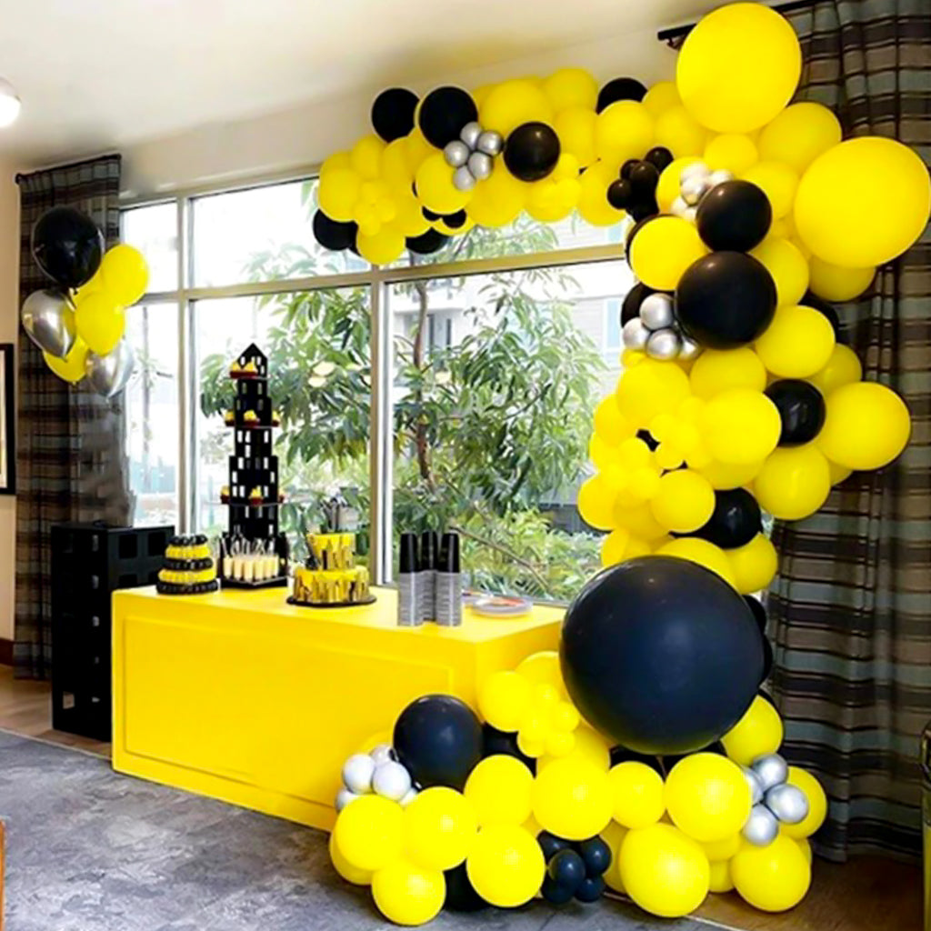 Bee themed balloon garland arch with yellow and black balloons of varying sizes.