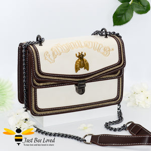 Rock chic styled vegan leather handbag featuring bold golden "Fabulous" embroidery with vintage gold bee embellishment in cream colour.