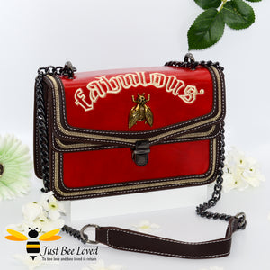 Rock chic styled vegan leather handbag featuring bold golden "Fabulous" embroidery with vintage gold bee embellishment in dark red colour.