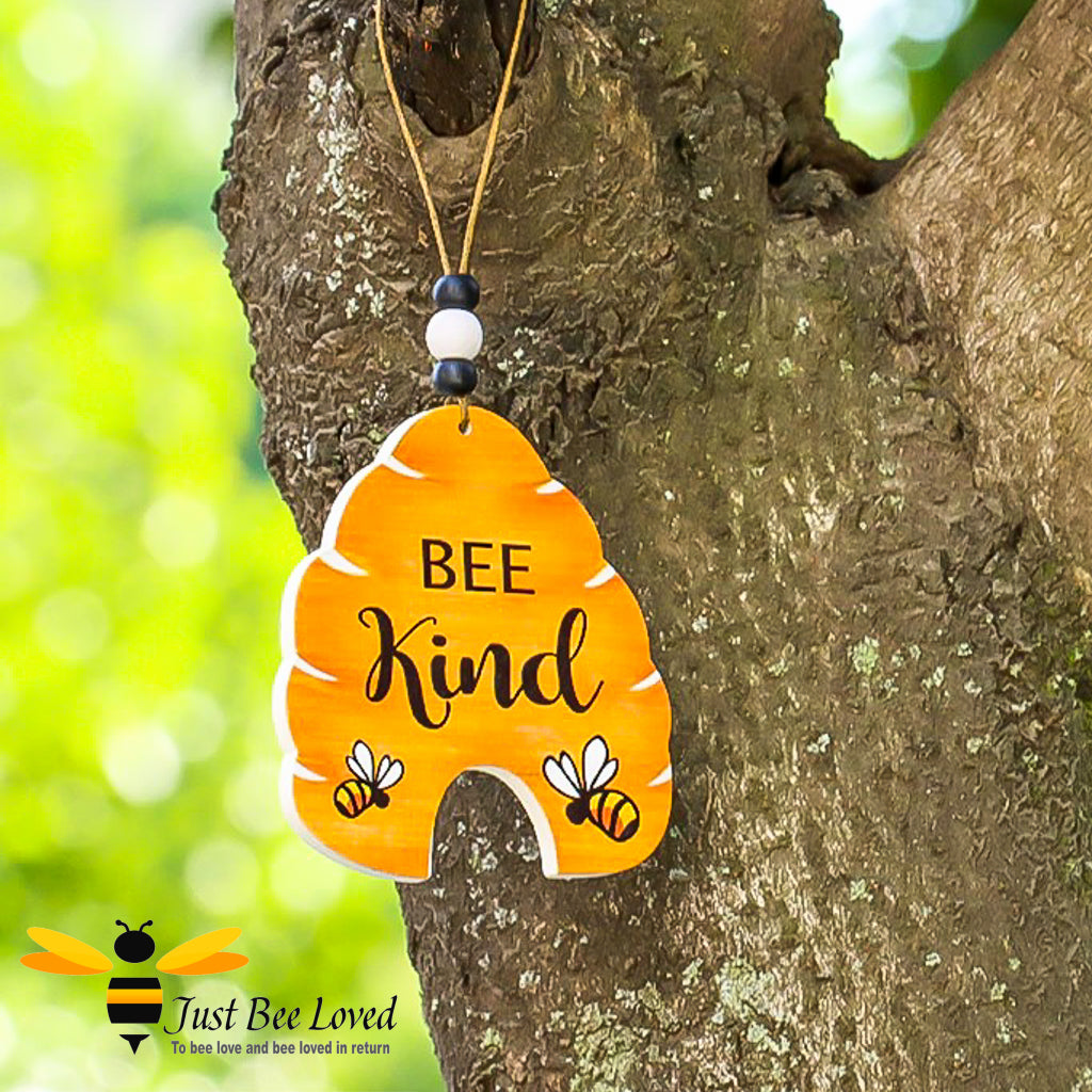 A wooden hive-shaped hanging mini sign with 'BEE Kind' text and bee illustrations.