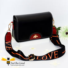 Load image into Gallery viewer, crossbody handbag in black and wine red, featuring a gold bee embellishment, wide matching canvas strap with &#39;LOVE&#39; text. 