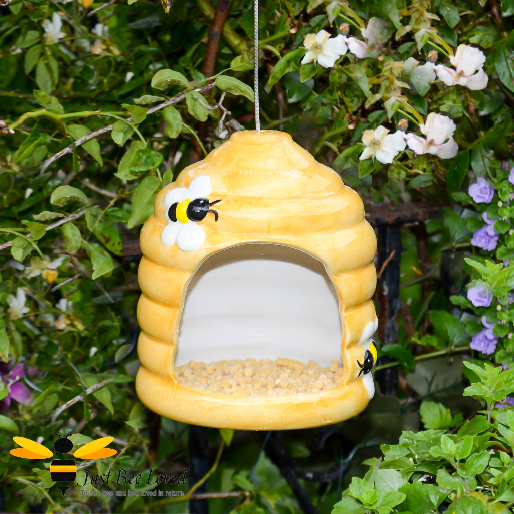 Yellow hand painted ceramic bird feeder in the shape of a beehive with bees