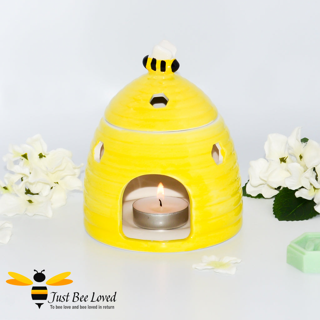 yellow ceramic wax melt & oil burner designed in the shape of a beehive with removable lid featuring a honey bee